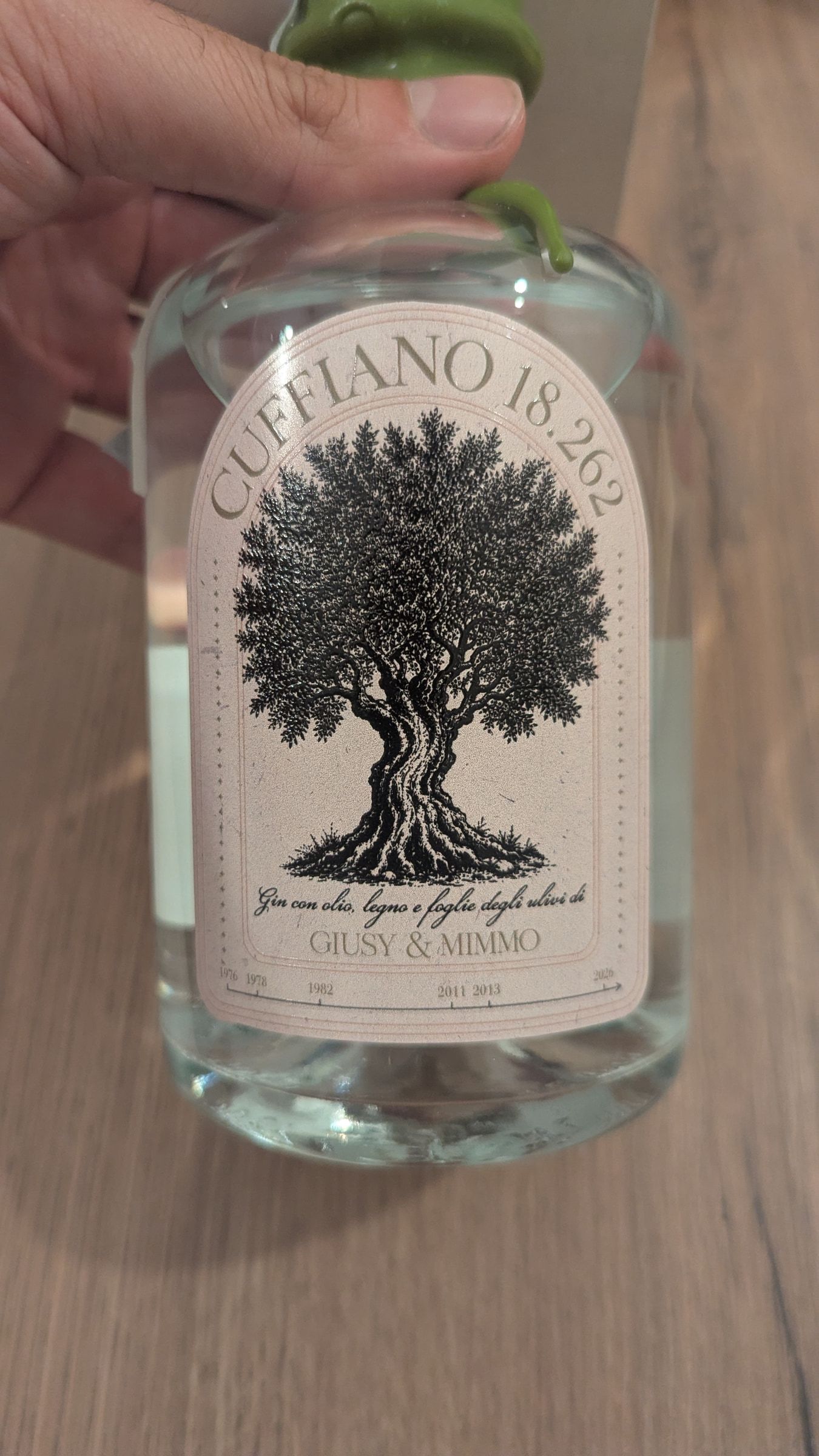 La bottiglia di Cuffiano 18.262 tenuta in mano, il tappo in ceralacca verde oliva.
