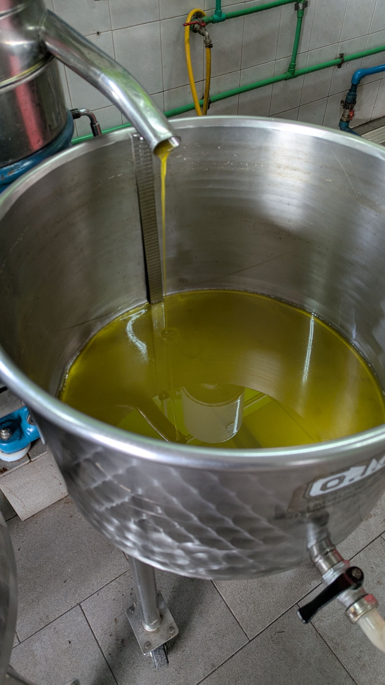 La colata di olio extravergine appena estratto, di un verde dorato intenso.